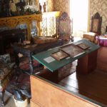 A. M. HOCH, interstices, DETAIL: parlor with embedded videos (in shoe on top of basket and ink bottle on top of book), 2002